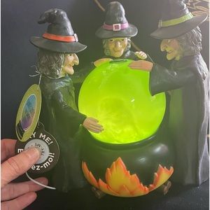 Three witches with magical bubbling cauldron